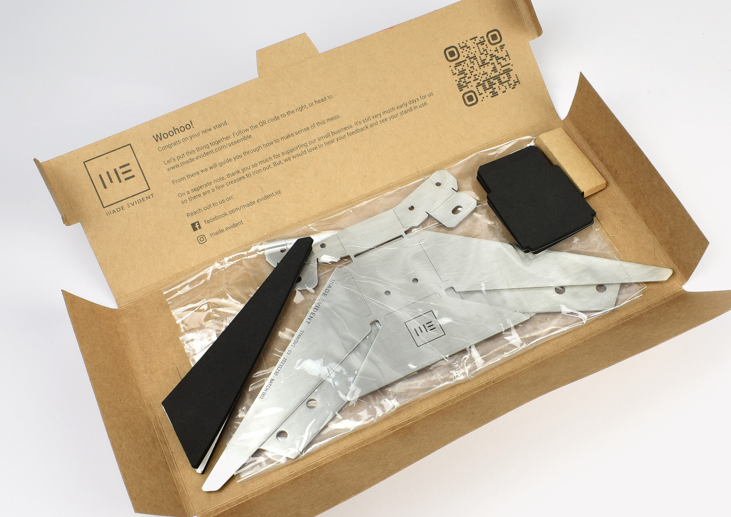 Flat-packed product alongside an instruction sheet, illustrating the unboxing experience and user-friendly assembly steps.