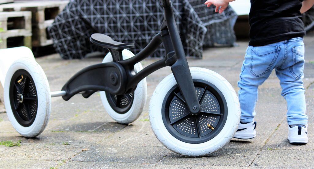 Sustainable balance bike designed by Evan Thomas, industrial designer Auckland, for Wishbone Design Studio — shown in use by a toddler.