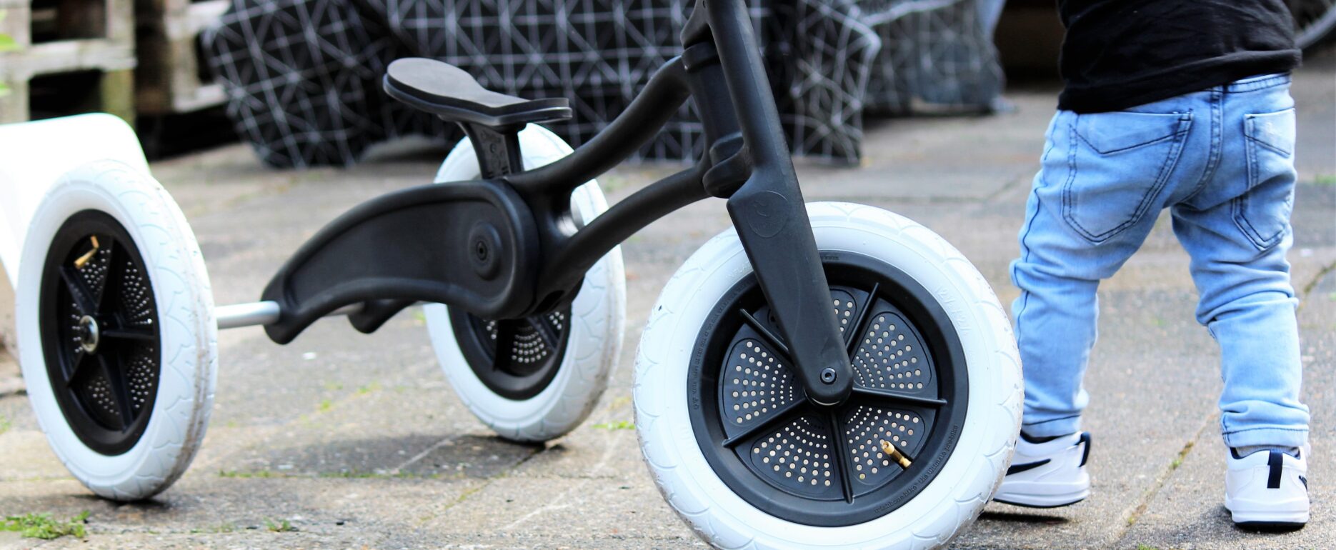 Sustainable balance bike designed by Evan Thomas, industrial designer Auckland, for Wishbone Design Studio — shown in use by a toddler.