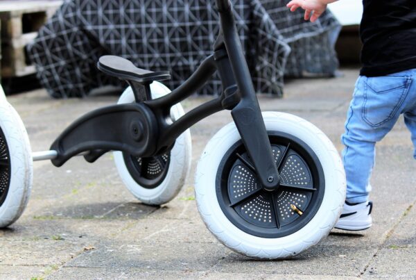 Sustainable balance bike designed by Evan Thomas, industrial designer Auckland, for Wishbone Design Studio — shown in use by a toddler.