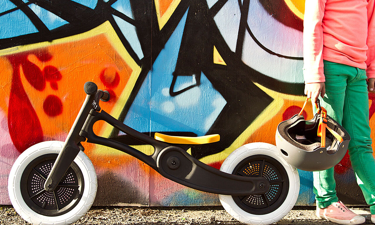 Finished balance bike in an outdoor setting, displaying the sleek design, recycled materials, and signature Wishbone aesthetic.