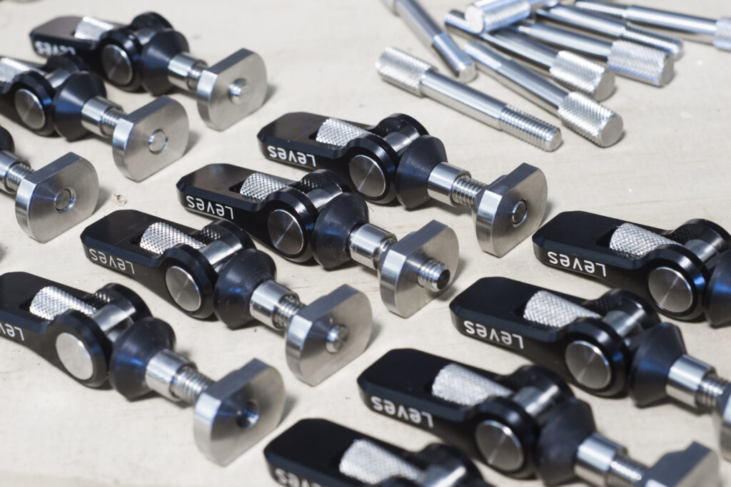 Leves foil quick release fasteners prototype foil quick release fasteners laid out across a workbench. Designed by ET-ID